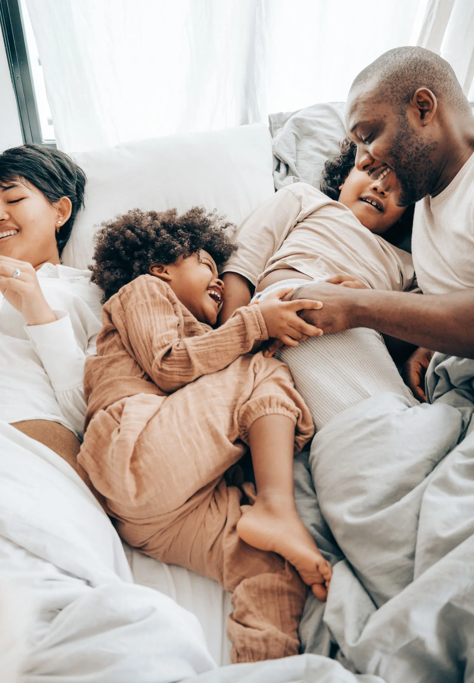 Family resting together in bed